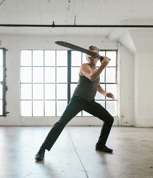 Man in a controlled strength pose, embodying focus and energy.